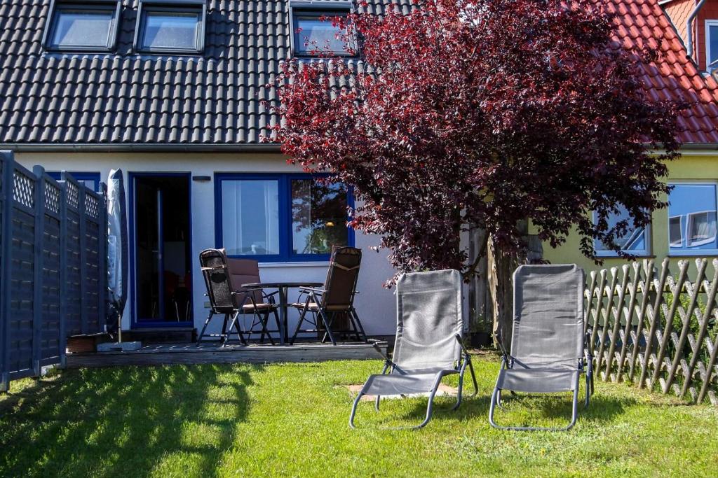 un grupo de sillas y una mesa en un patio en Dat blaue Huus - Am Tor zum Darß en Pruchten