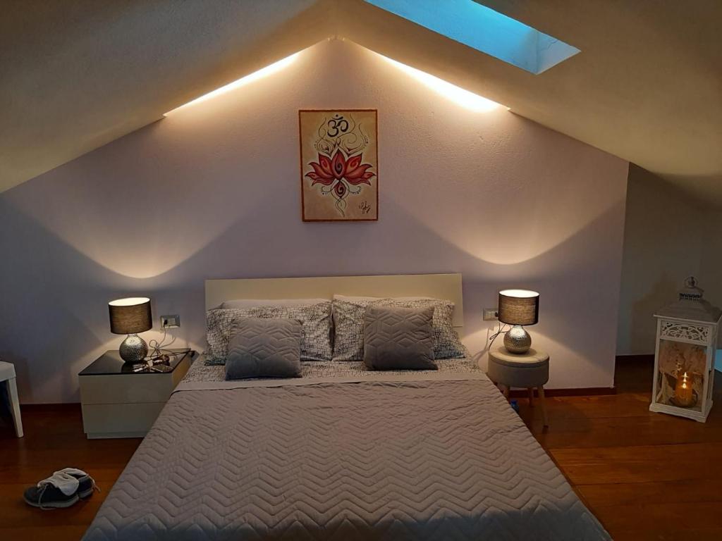 a bedroom with a large bed with two lamps at Home Holiday 304 in Iglesias