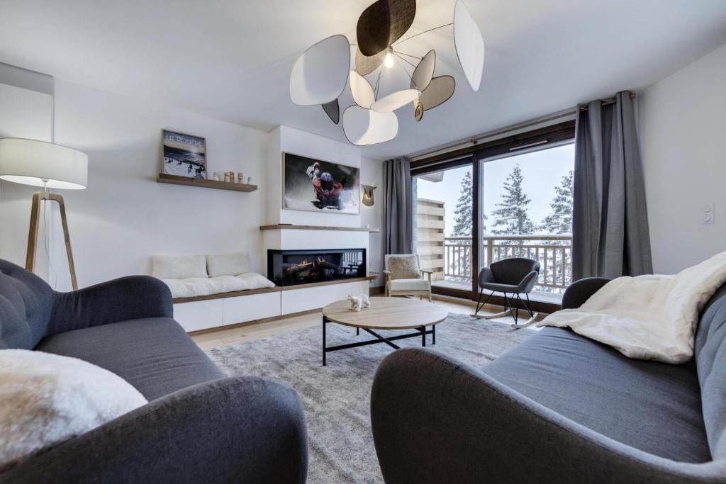 a living room with two couches and a fireplace at Résidence Les Alpages - Pièces 884 in La Rosière