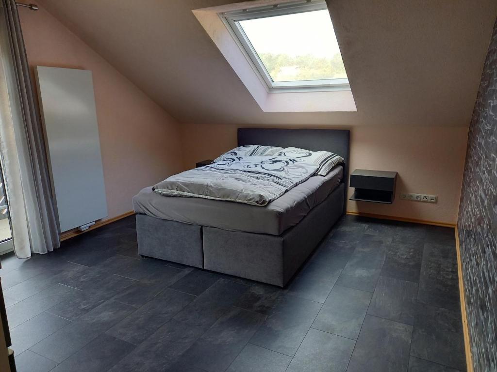 um quarto com uma cama num quarto com uma janela em Ferienwohnung Haus Peterstal em Trulben