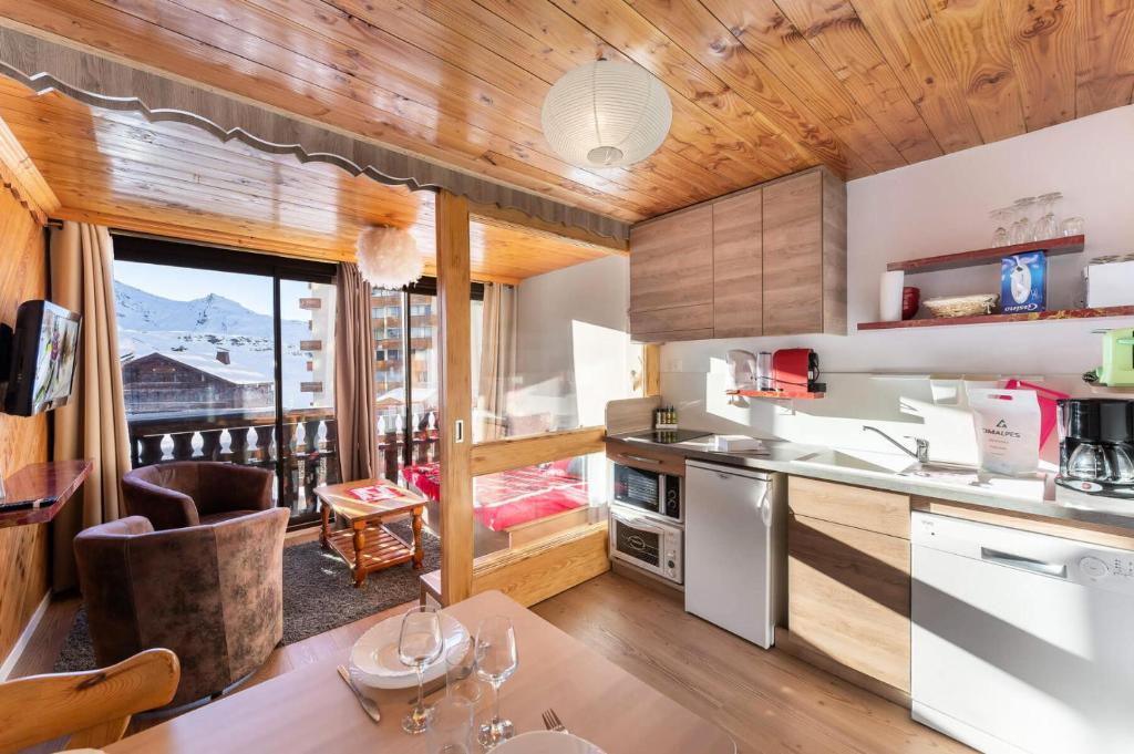 Il comprend une cuisine avec des plafonds en bois et un balcon. dans l'établissement Résidence Le Serac - Studio pour 4 Personnes 294, à Val Thorens