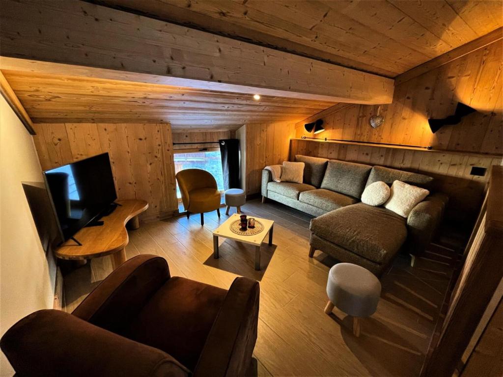 una sala de estar con sofás y TV en una casa en Chalet Aster - 4 Pièces pour 6 Personnes 444 en Saint-Marcel
