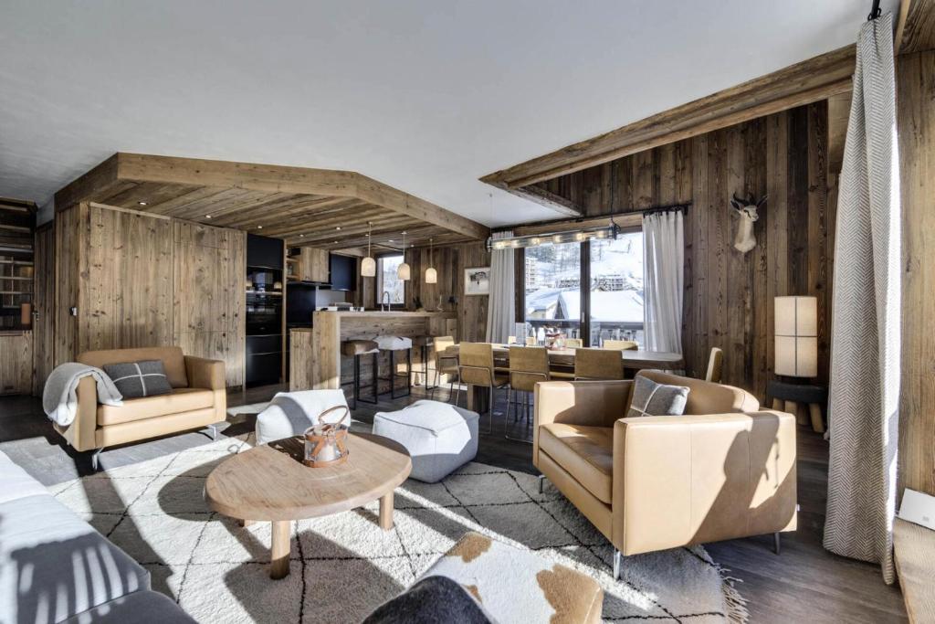 una sala de estar con paredes y muebles de madera. en Residence La Canadienne - 5 Pièces pour 8 Personnes 554, en Val dʼIsère