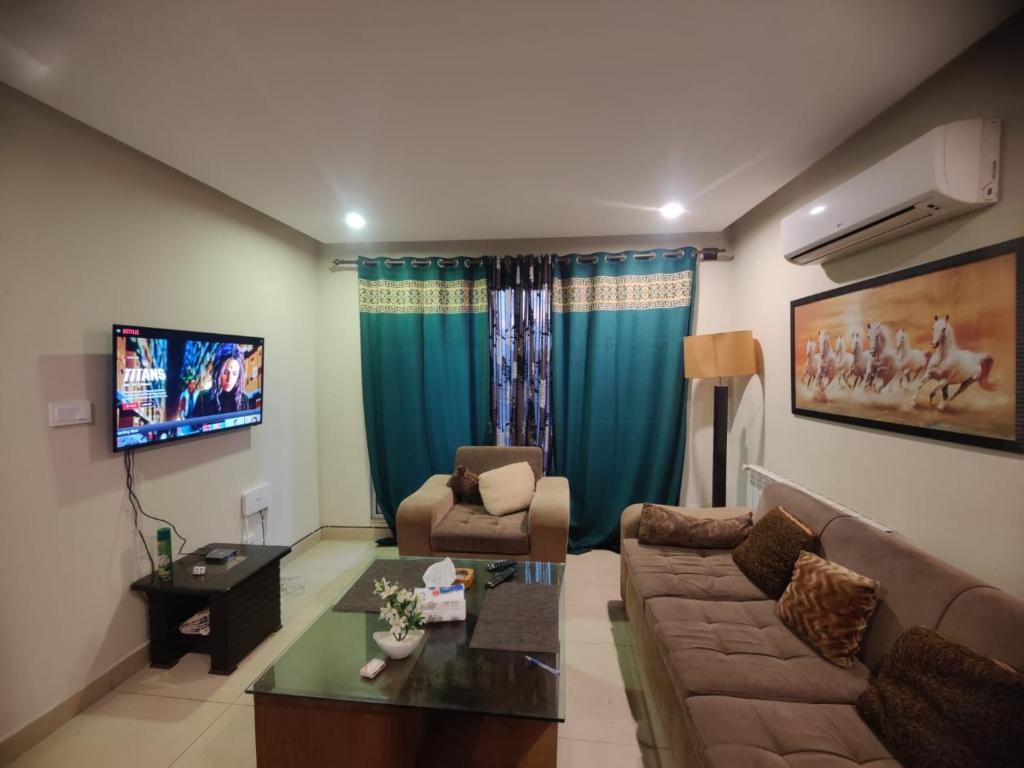 - un salon avec un canapé et une table dans l'établissement Urbanized Comfy Apartment, à Rawalpindi