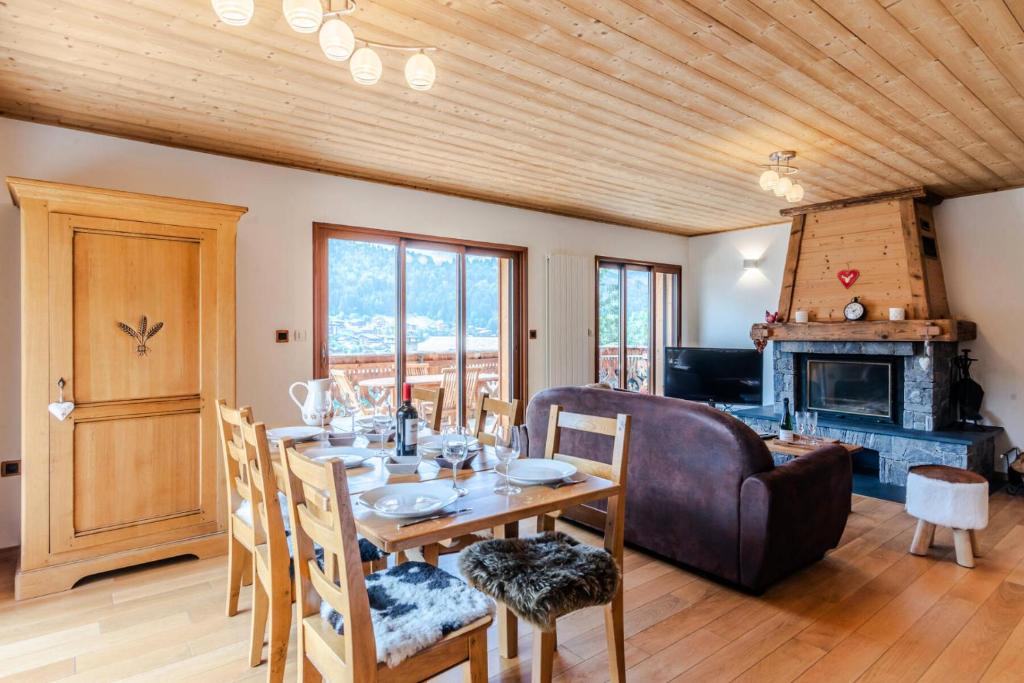 une salle à manger avec une table et une cheminée dans l'établissement Chalet L'ourson Blanc Morzine - 3 Pièces pour 6 Personnes 514, à Morzine