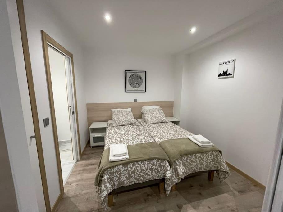 1 dormitorio con 1 cama grande en una habitación blanca en Studio 11 RDC, au calme, 1 a 2 Couchages, en Le Pin