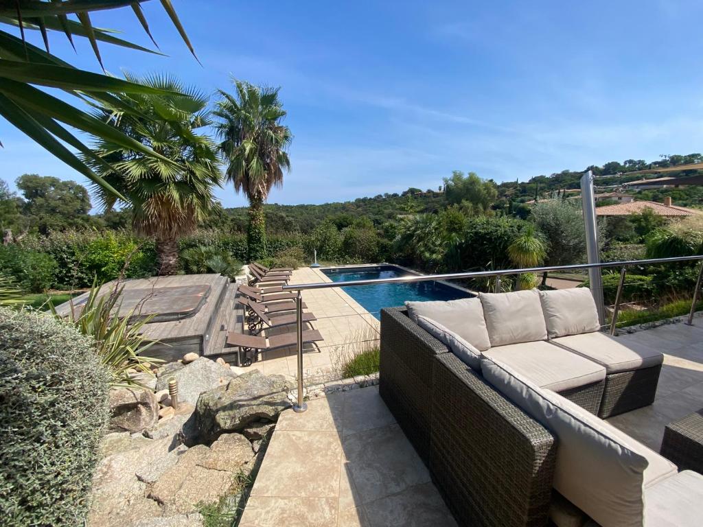 - un canapé installé sur une terrasse à côté de la piscine dans l'établissement Villa valle longa capicciola, à Sainte-Lucie de Porto-Vecchio