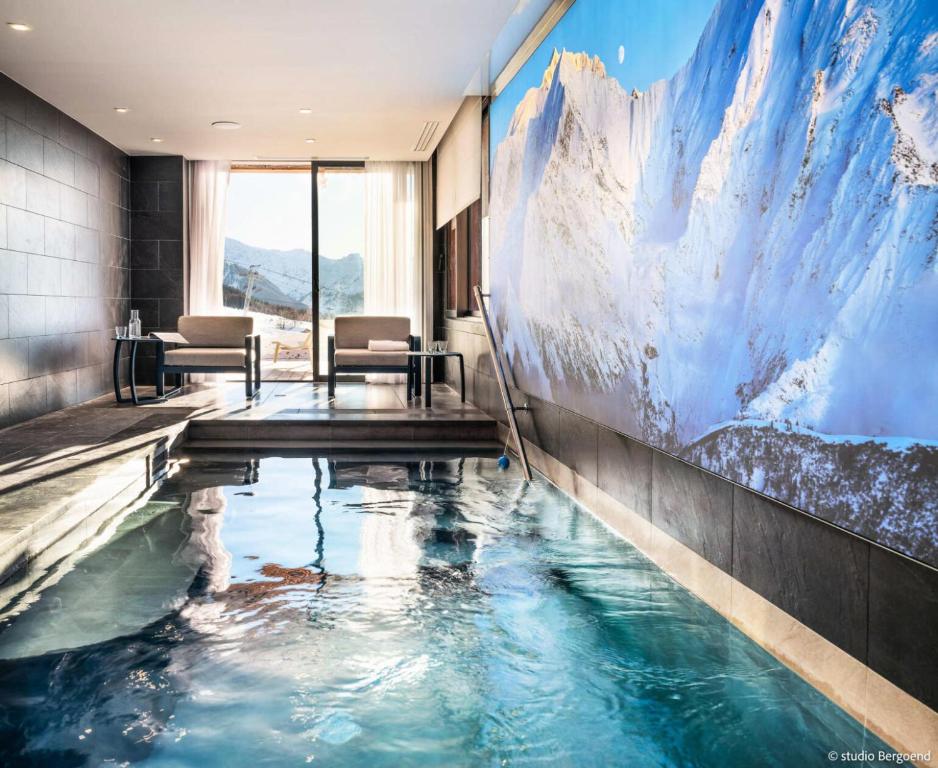 a swimming pool in a hotel room with a painting on the wall at Résidence Arpoza - Chalets pour 15 Personnes 094 in Arc 1800