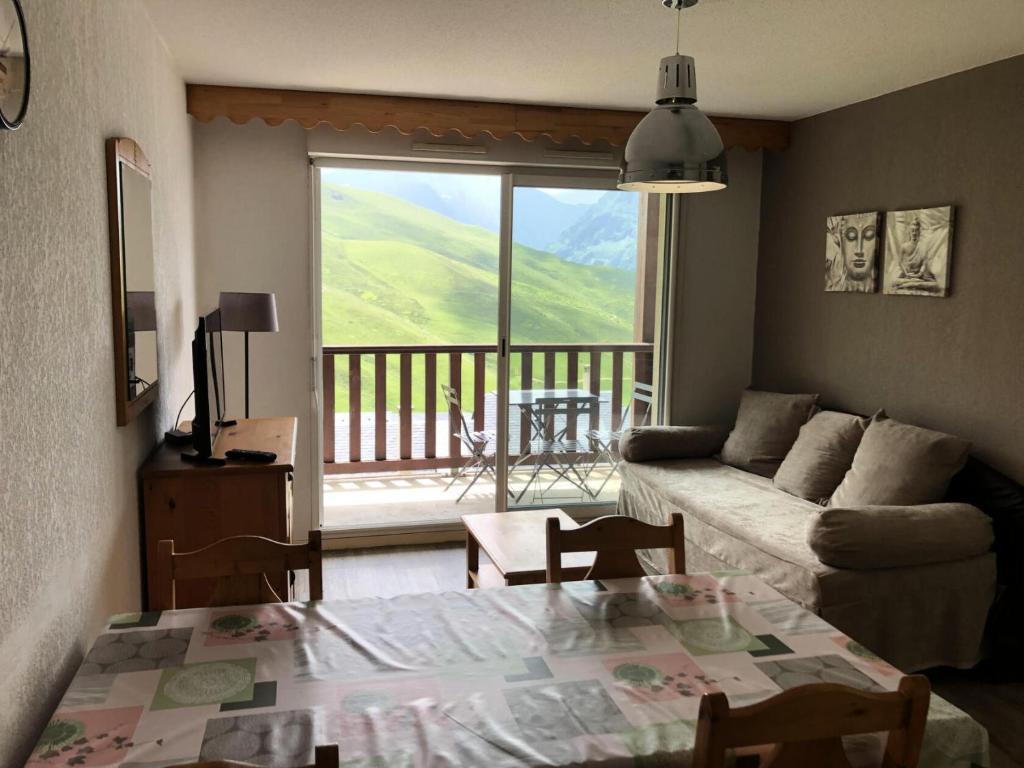 a living room with a couch and a table with a view at Résidence Hauts De Peyragudes Mp - 2 Pièces pour 6 Personnes 844 in Germ
