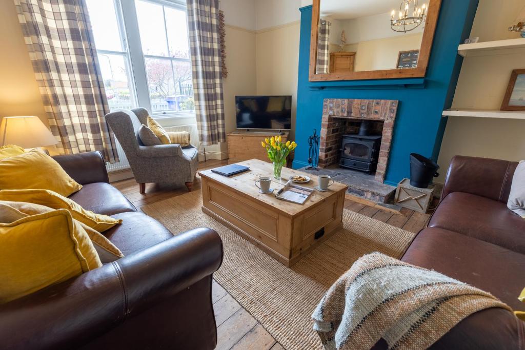 a living room with a couch and a coffee table at Pebble Cottage in Seahouses