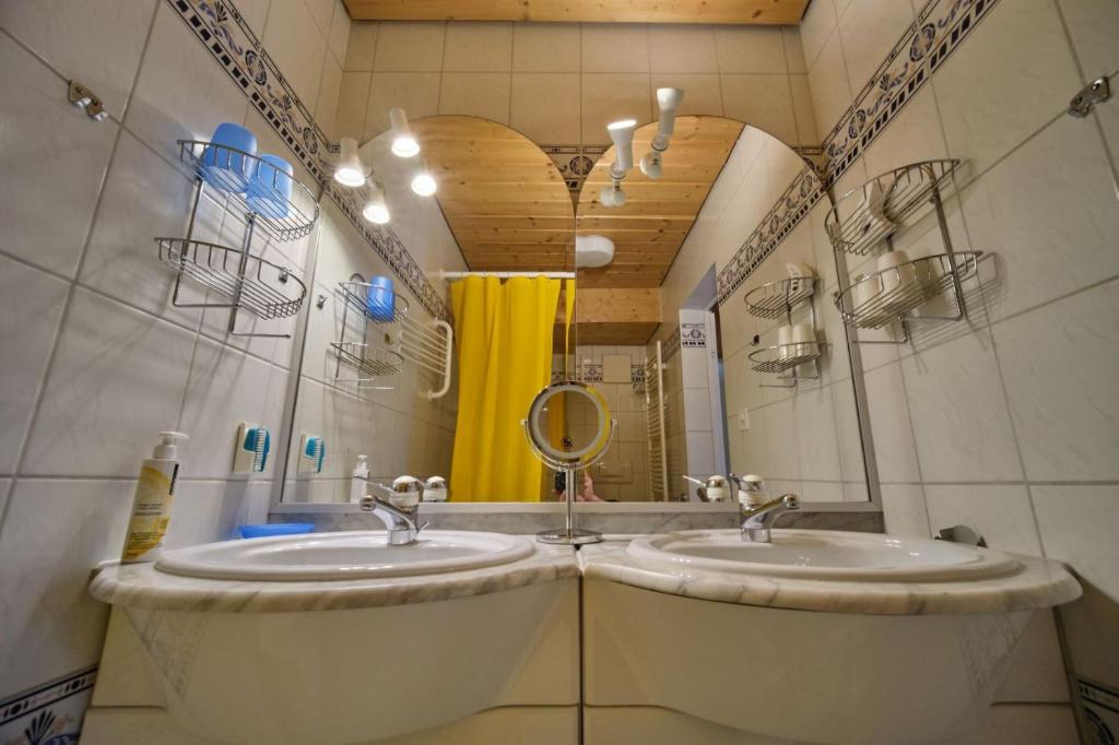 baño con 2 lavabos y espejo grande en Chasa Panorama, en Scuol