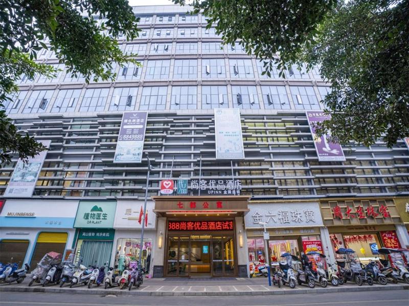 a large building with motorcycles parked in front of it at Thank Inn Chain Wenshan Yanshan Qidu Plaza in Yanshan
