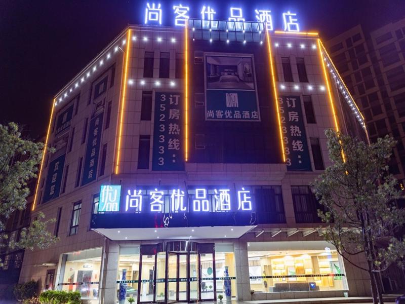 een gebouw met neonborden aan de zijkant bij Thank Inn Chain Yingtan Guixi Eagle Avenue Shengfeng in Guixi