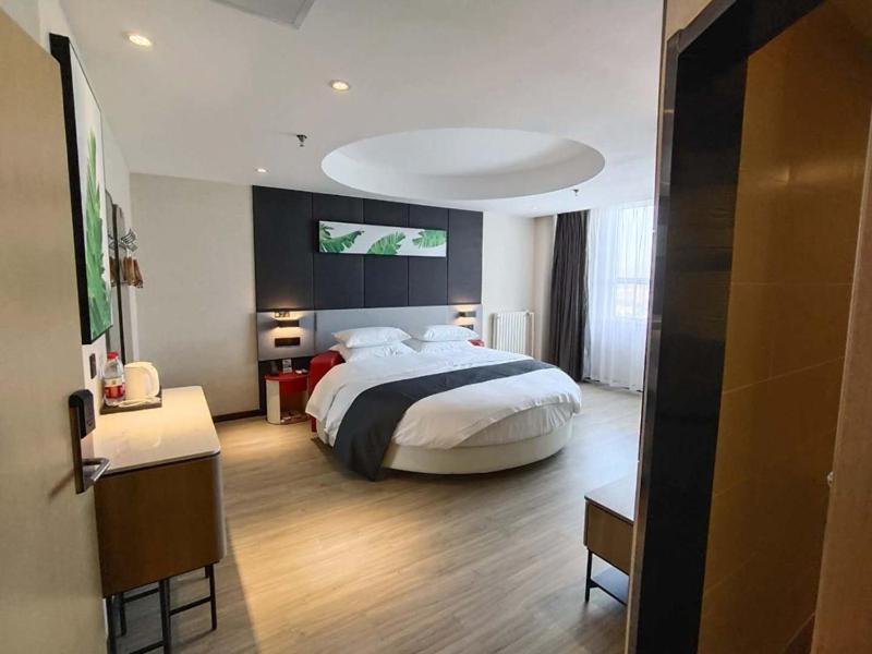 ein Schlafzimmer mit einem großen Bett in einem Zimmer in der Unterkunft Thank Inn Chain Shijiazhuang Railway Station East Plaza in Shijiazhuang