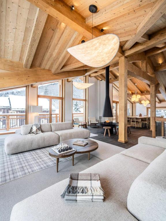 a living room with couches and a wooden ceiling at Résidence Beloukha - Chalets pour 12 Personnes 734 in Saint-Bon-Tarentaise
