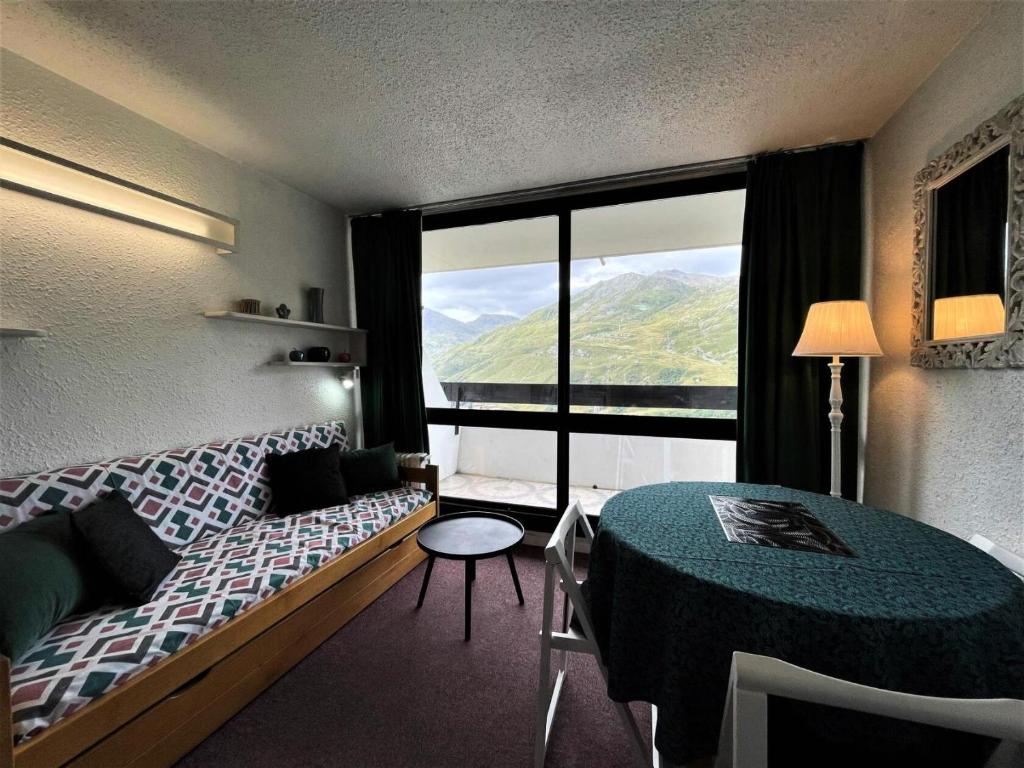 a hotel room with a bed and a large window at Résidence Tougnette - Studio pour 3 Personnes 494 in Les Menuires