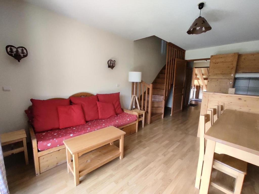 - un salon avec un canapé et des oreillers rouges dans l'établissement Les Chalets Des Rennes - Appartement 3 pièces - Les Chalets Des Rennes MAE-9604, à Vars