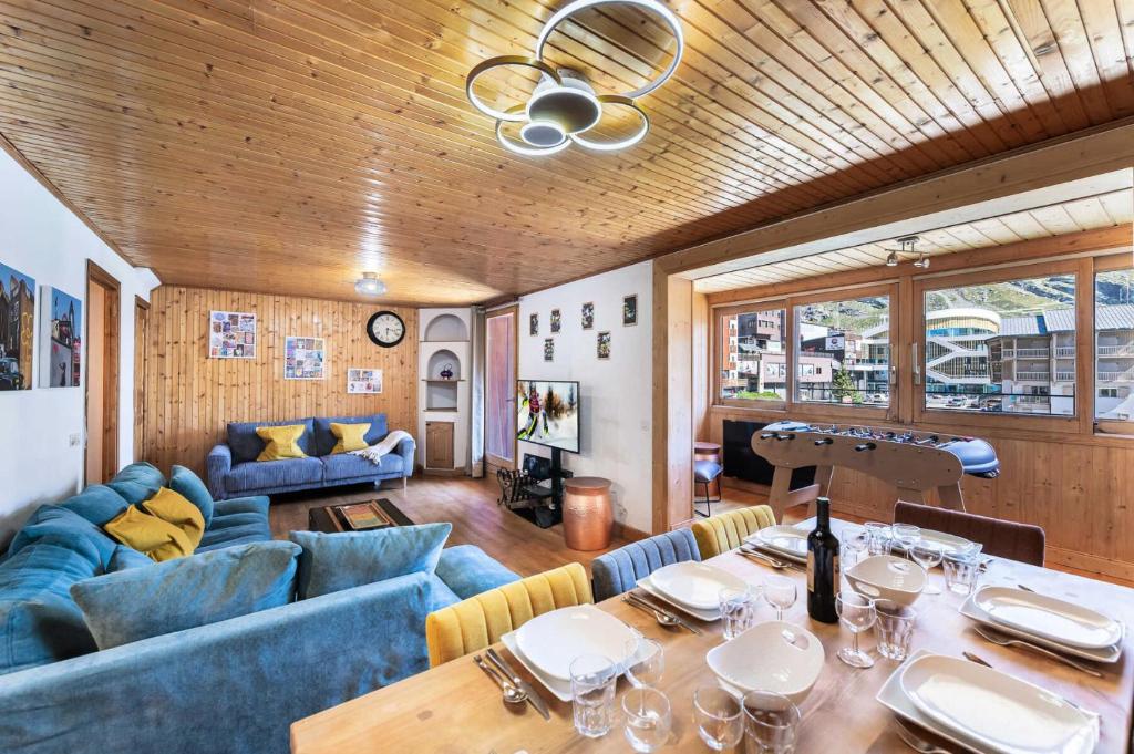 a living room with blue couches and a dining table at Résidence Valset - 3 Pièces pour 9 Personnes 984 in Val Thorens