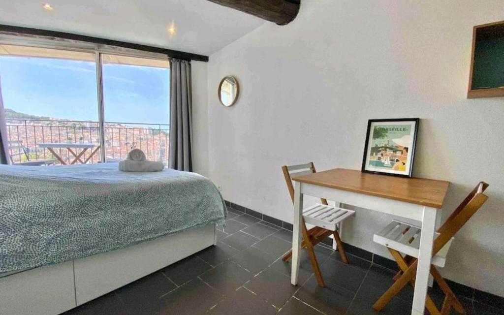 une chambre avec un lit, un bureau et une fenêtre dans l'établissement Belle vue de Notre Dame du Mont by Weekome, à Marseille