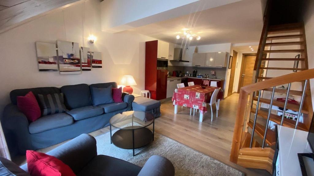 un salon avec un canapé bleu et une cuisine dans l'établissement Résidence Loup Argente - Superbe duplex très lumineux, face aux pistes MAE-3944, à Montgenèvre