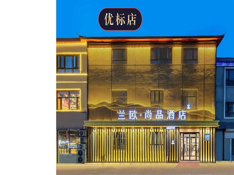 un bâtiment jaune avec des écrits chinois sur son côté dans l'établissement LanOu Hotel Langfang Gu'an Daxing Airport Wildlife Park, à Langfang