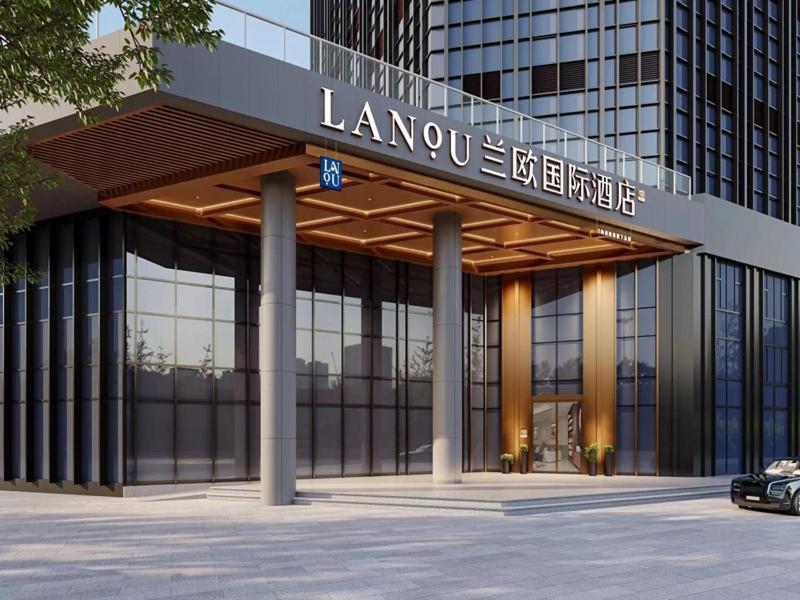 a large glass building with a sign on it at LanOu Hotel Suqian Central Shopping Mall in Suqian