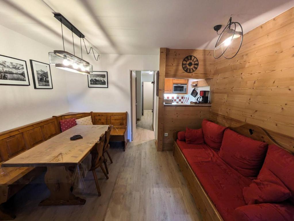 een woonkamer met een rode bank en een tafel bij Résidence Jonquille - 2 Pièces pour 4 Personnes 974 in Chamonix-Mont-Blanc