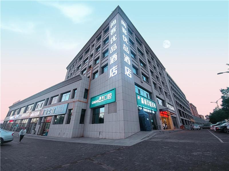 a large building with a sign on the front of it at Thank Inn Chain Yulin Yuyang Jinsha Road in Yulin