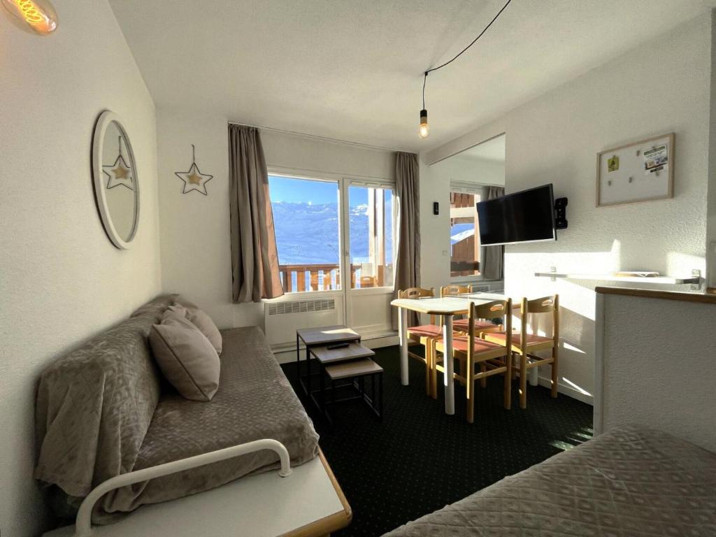 un salon avec un canapé et une table et une cuisine dans l'établissement Résidence Necou - Appartement pour 4 avec chambre MAE-3904, aux Menuires