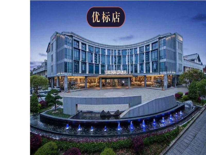 a large glass building with a fountain in front of it at LanOu M Hotel Shangxing Luxun's Hometown in Shaoxing