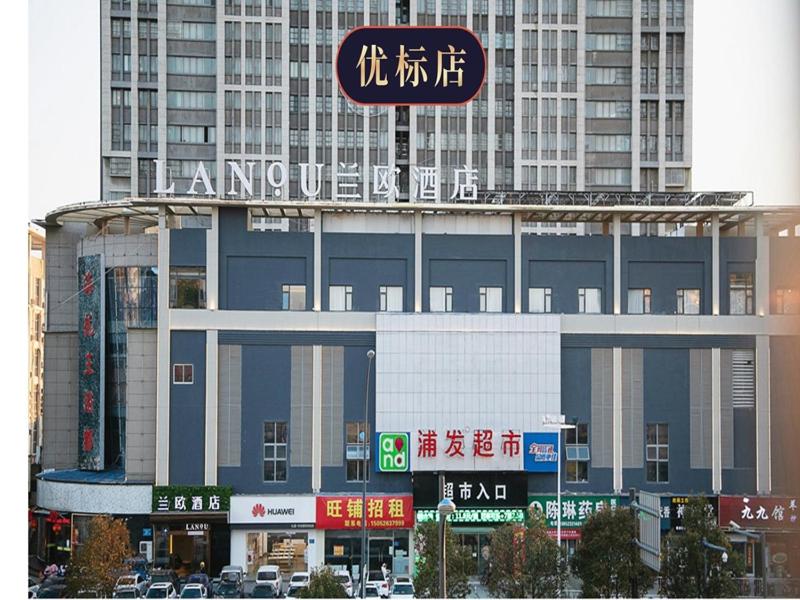 un gran edificio con un cartel encima en LanOu Hotel Huai'an Lianshui High-Speed Railway Station Yanhuang Avenue en Lianshui