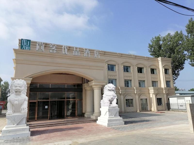a large building with two statues in front of it at Thank Inn Chain Beijing Fanshan Chengguan Town Fangshan Red Scarf Park in Fangshan