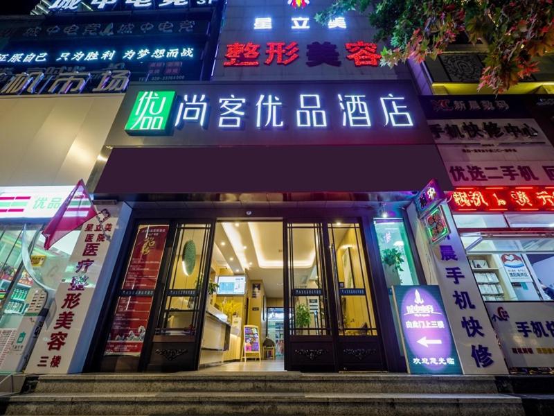 a building with neon signs on the front of it at Thank Inn Chain Xianyang Renmin Road Central Plaza in Xianyang