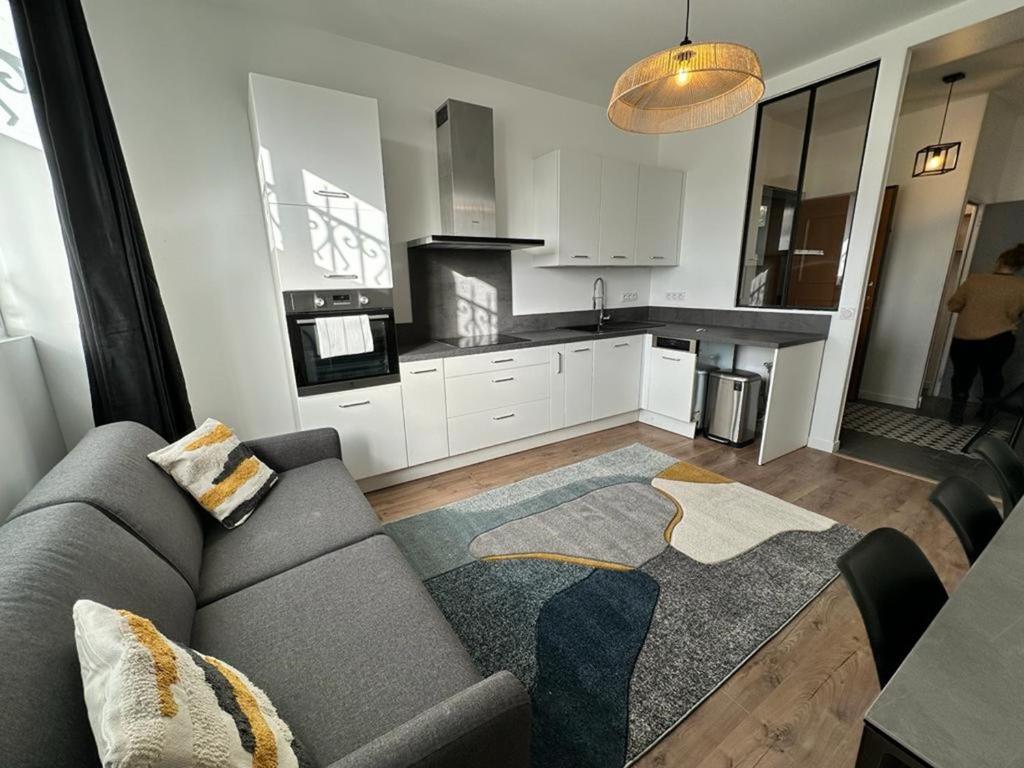 ein Wohnzimmer mit einem Sofa und einer Küche in der Unterkunft Urban Flat 169 - Pretty Flat Bercy Coriolis in Paris