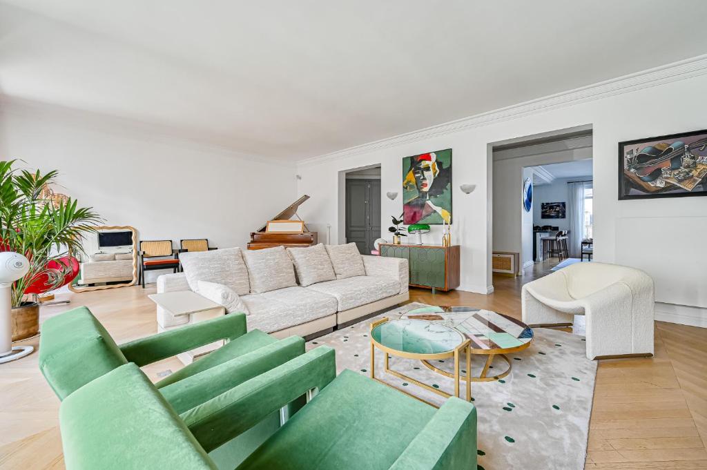 a living room with a white couch and green chairs at Gorgeous Paris Eiffel Tower - Champs Elysées in Paris