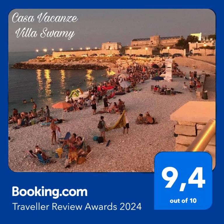 a group of people on a beach near the water at Villa swamy in Bisceglie