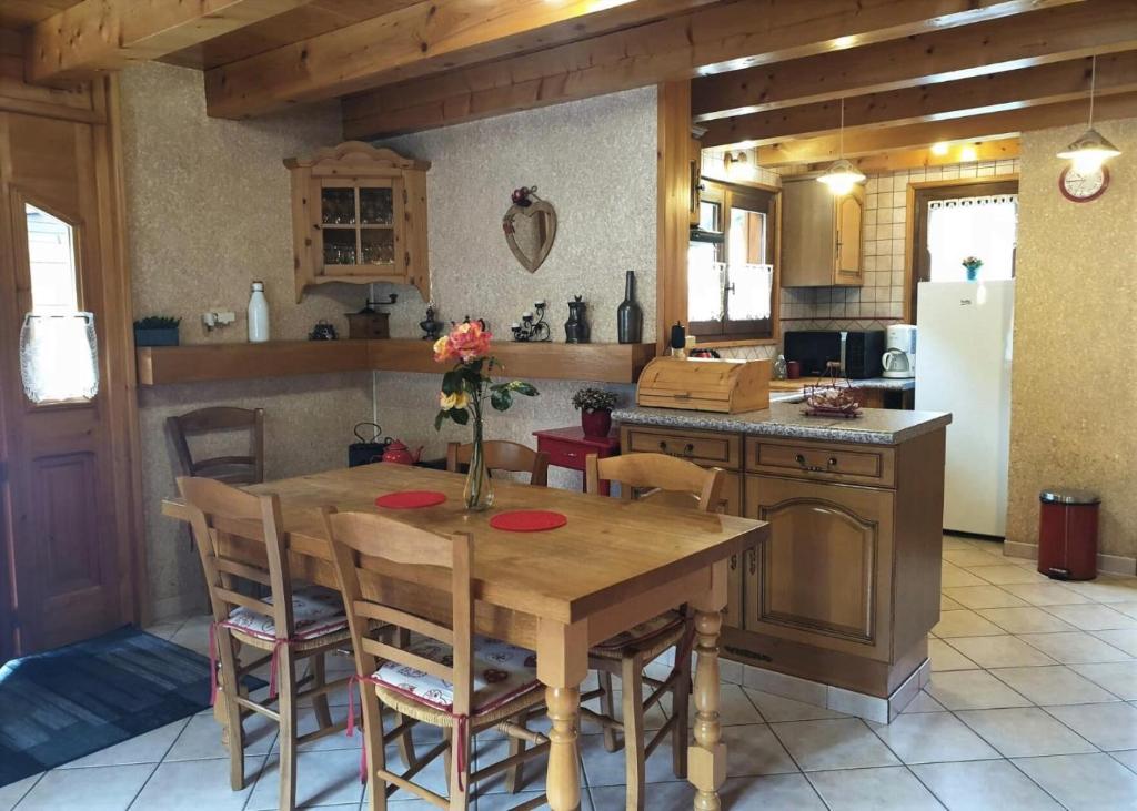 een keuken met een houten tafel met stoelen en een koelkast bij Chalet Cosy - Chalets pour 5 Personnes 111 in Morzine