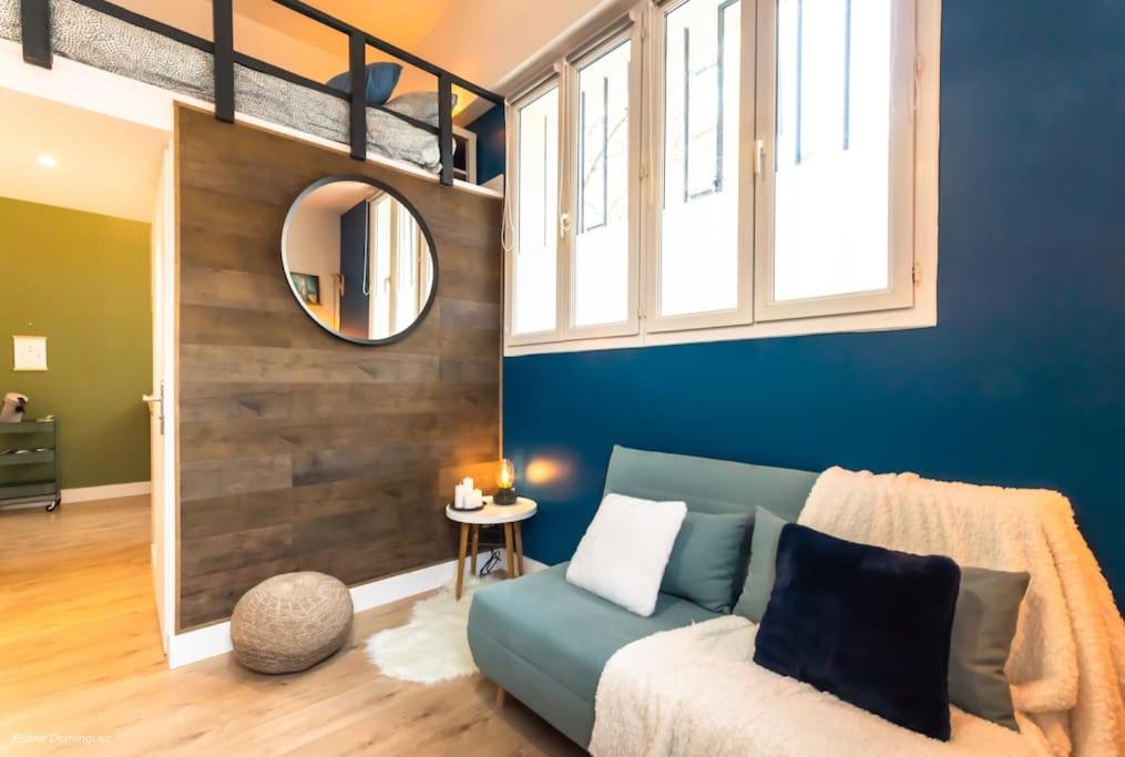 un salon avec un canapé et un miroir dans l'établissement T1 Cosy prox. Gare , commerces et centre ville, à Villeurbanne
