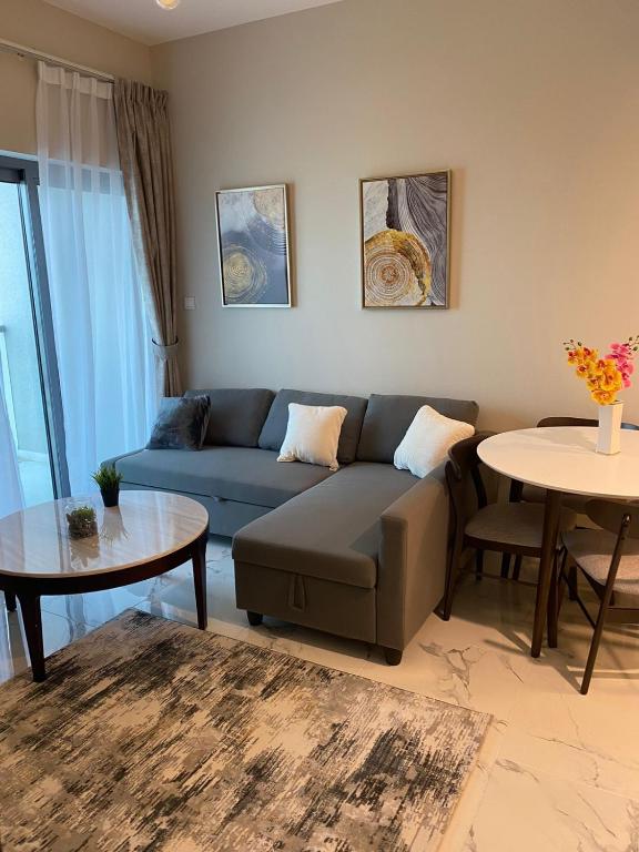 a living room with a couch and a table at StoneTree - Cozy and Modern 1 BR in Dubai