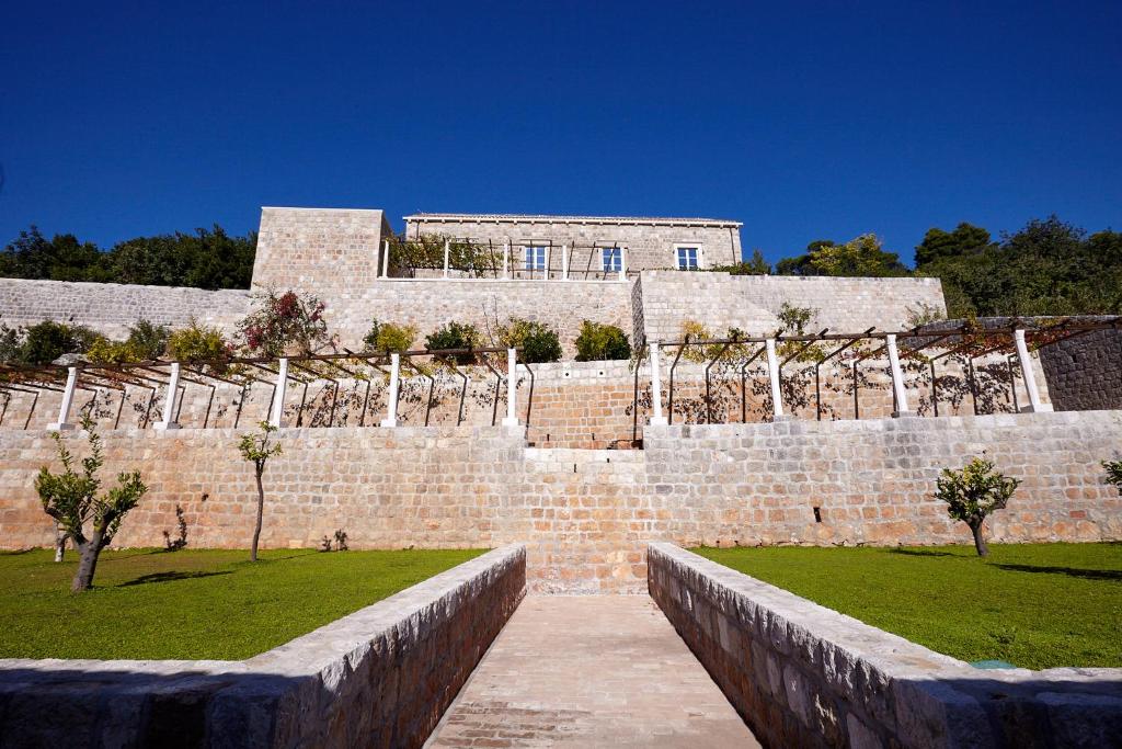 um edifício de tijolos com árvores em frente em Renaissance Palace Ghetaldi 1516 em Suđurađ