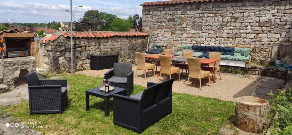 um pátio com uma mesa e cadeiras e uma lareira em maison de charme avec jardin em Cousance