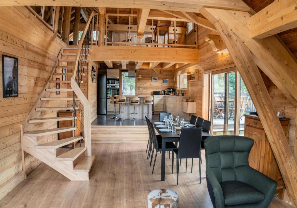 a dining room and kitchen with a staircase in a log cabin at Résidence Pramouton - Chalets pour 9 Personnes 591 in Le Mélézet