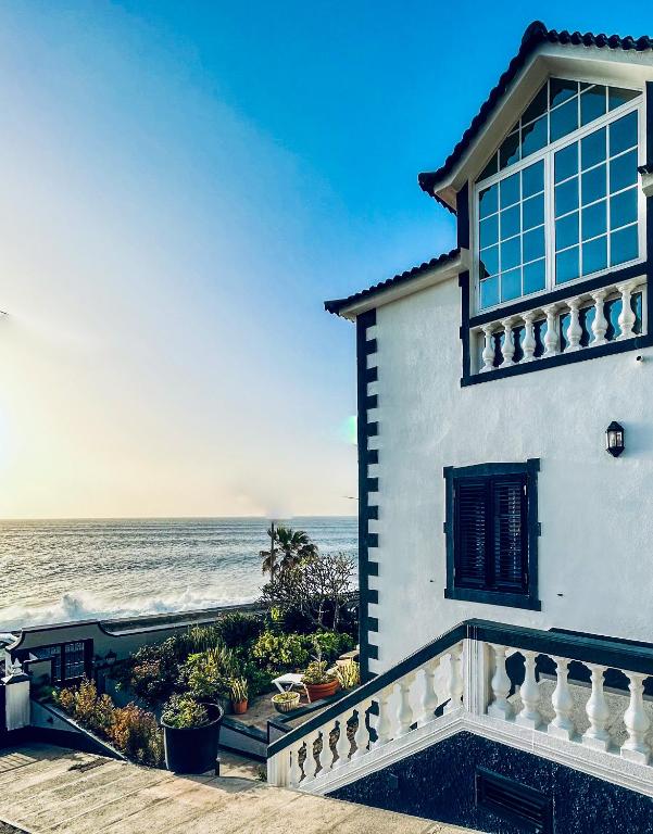 a white house with the ocean in the background at Casa Carneirinho by Olá Madeira in Paul do Mar