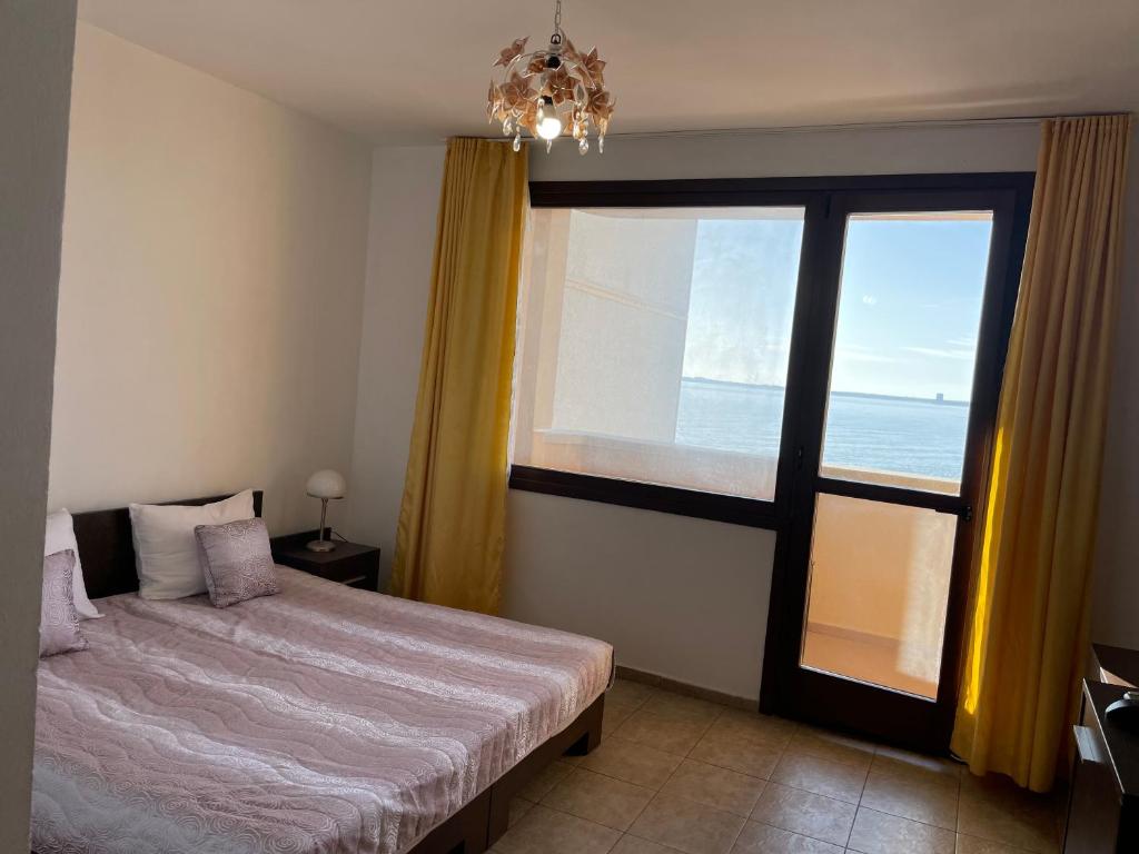 een slaapkamer met een bed en een groot raam bij Villa Sun Palace in Sveti Vlas