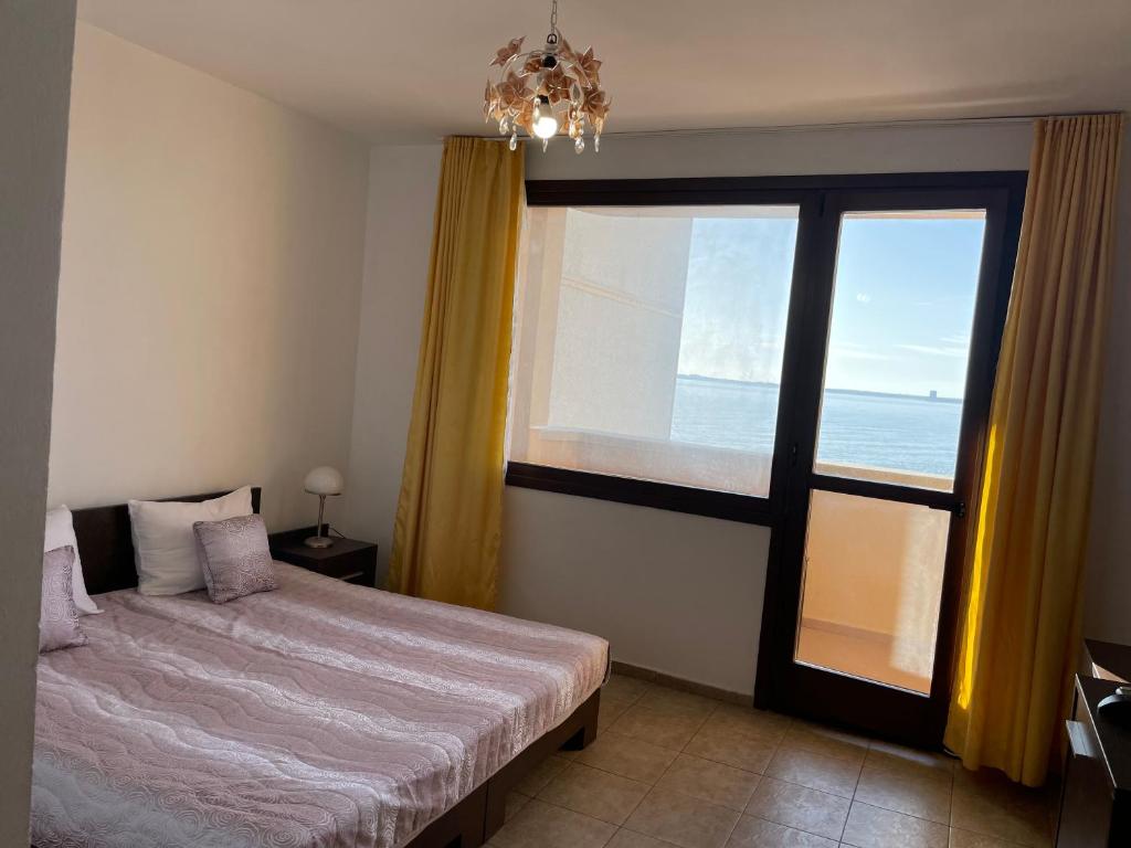 a bedroom with a bed and a large window at Villa Sun Palace in Sveti Vlas