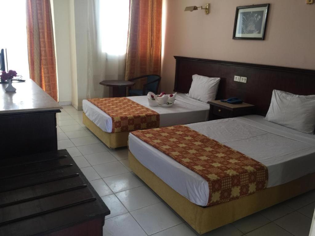 Regency Lodge Hotel في شرم الشيخ: غرفة فندقية بسريرين وطاولة