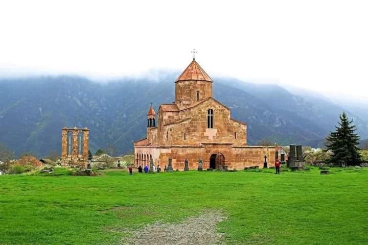 an old church in a field of green grass at Tsatʼer Guest House in Tsatʼer