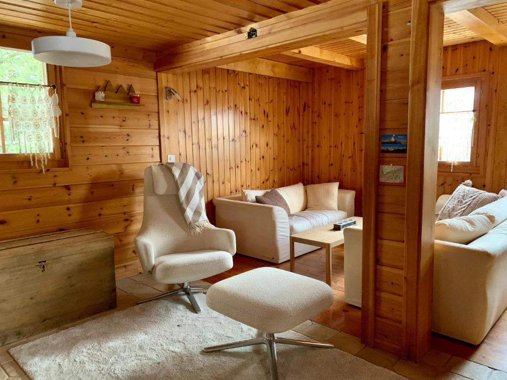 uma sala de estar com duas cadeiras e um sofá em Chalet typique tout confort avec studio en dessous em Hérémence