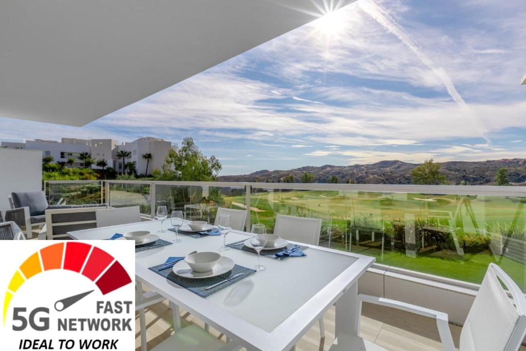 a white table and chairs on a balcony with a view at Apartment front Line La Cala Golf Resort in La Cala de Mijas