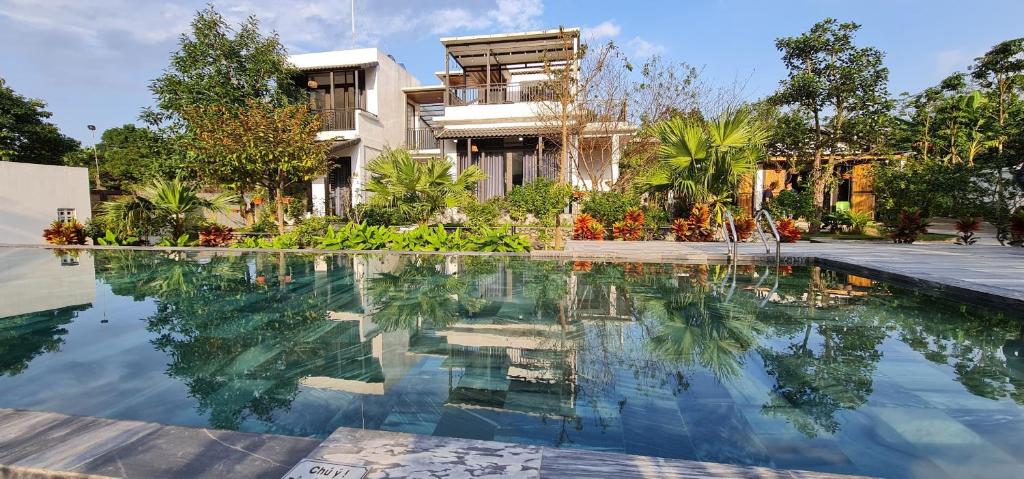 a house with a swimming pool in front of a house at Xoan Villa - Venuestay in Ba Vì